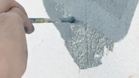 Side view of painting a mural on a wall with brush and roller and palette. Video stock 141766610