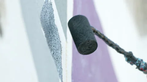 Side view of painting a mural on a wall with brush and roller and palette. Stock Footage 141766626