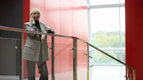 A side view panoramic shooting of a blonde business woman in a grey overcoat Stock Footage 137815441