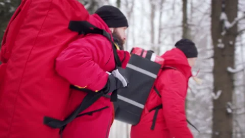 Side view of paramedics from mountain rescue service running outdoors in winter Video stock 161315084