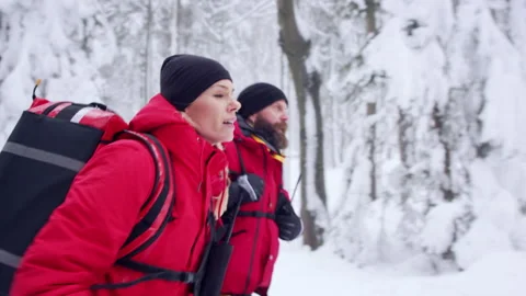 Side view of paramedics from mountain rescue service running outdoors in winter 스톡 동영상 162100293