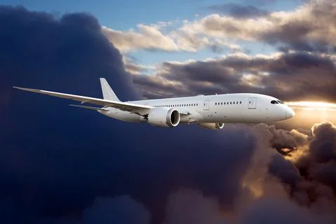 Side view of a passenger plane flying above the storm clouds Stock Photos