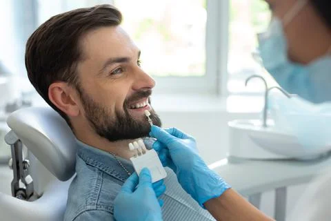 Side view of patient choosing tooth implants with doctor in hospital Stock Photos