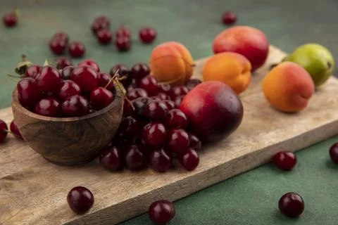 Side view of pattern of fruits as apricots peaches pear cherries with bowl .. Stock Photos