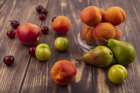 Side view of pattern of fruits as peach cherries plums pears and jar of apr.. Stock Photos