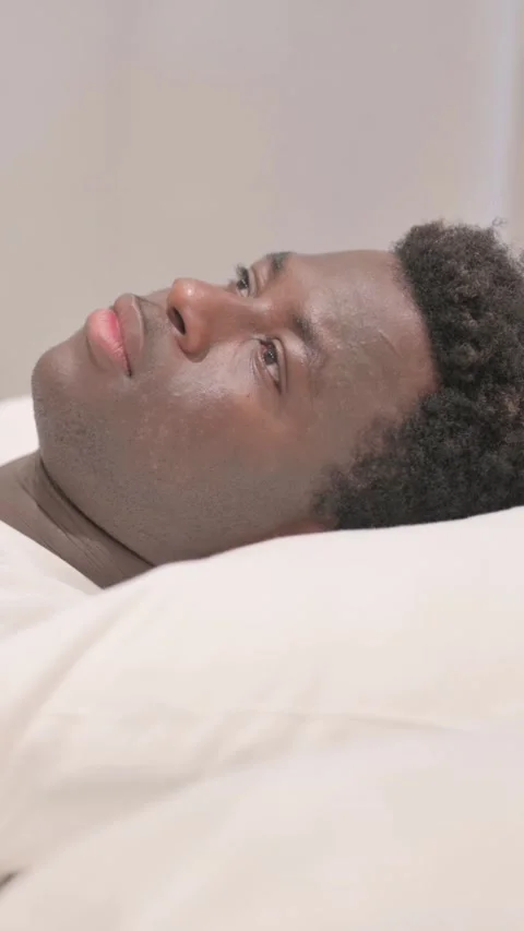 Side View of Pensive African American Man Sleeping in Bed, vertical video Stock Footage 328568598