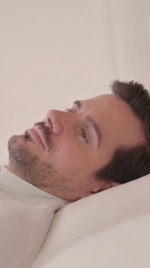 Side View of Pensive Young Man Sleeping in Bed, vertical video Stock Footage 328564980