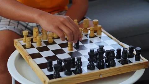 Side view of person arranging chess pieces on wooden board while relaxing on Stock-Footage 346029693