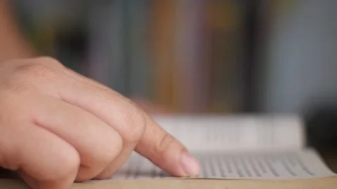 Side view of a person hand touching page when reading a book Stock Footage 231390901