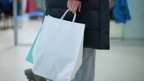 Side View of Person Walking Past Retail Display in Well-Lit Mall Carrying Vidéo 302261841