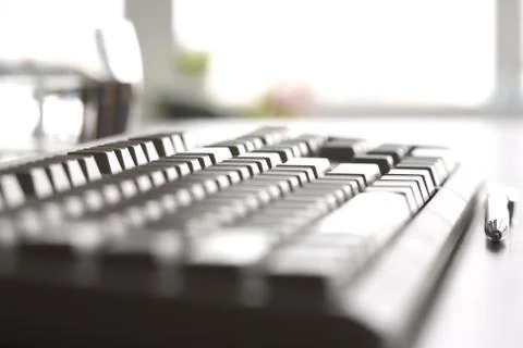 Side view of personal computer keyboard with pen near by Stockfoto's