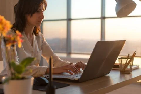 Side view photo of a female programmer using laptop, working, typing, surfing Stock Photos