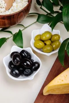 Side view of pickled olives with various kind of cheese on white background Stock-Fotos