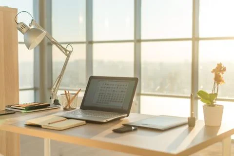 Side view picture of studio workplace with blank notebook, laptop. Comfortable Stock Photos