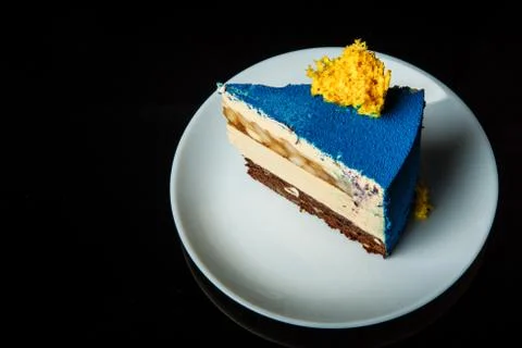 Side view of piece of blue mousse cake on white plate Foto stock