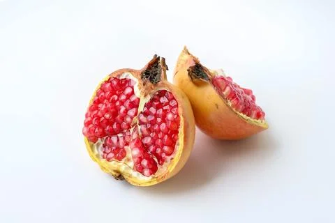 Side view of a pomegranate fruit separated in half on a white background Stock Photos