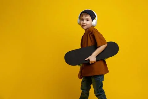 Side view portrait of a cute 6-7 year old kid, dressed in a denim shirt, holding Stock Photos