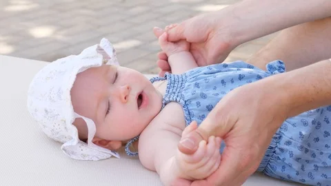 Side view portrait of cute adorable baby girl wearing blue body and white hat Stock Footage 98757444