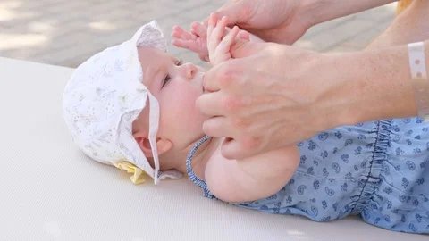 Side view portrait of cute adorable baby girl wearing blue body and white hat Stock Footage 98757447