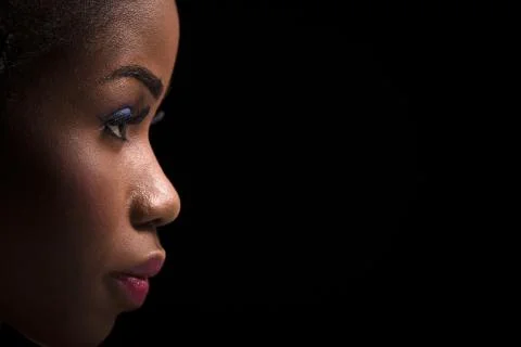 Side view portrait of dark skinned model on a black background. Stock Photos