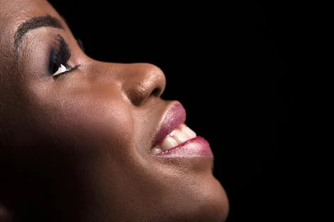 Side view portrait of dark skinned model on a black background. Stock Photos
