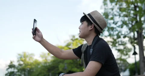 Side view Portrait of Happy Young Asian traveler man with hat video call  Stock-Footage 172462475