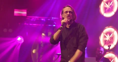 Side view portrait of a man singing to microphone on light background. Stylish Stock Footage 154277330