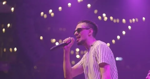 Side view portrait of a man singing to microphone on light background. Stylish Stock Footage 205849067