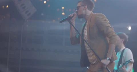 Side view portrait of a man singing to microphone on light background. Stylish Stock Footage 205867698