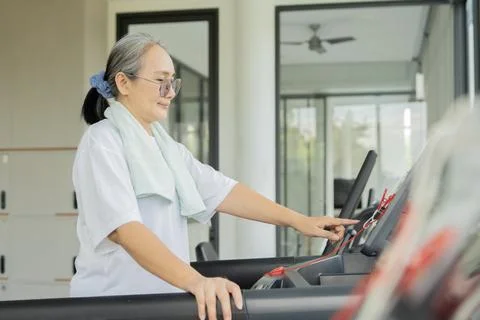 Side view portrait of smiling middle aged woman working out gym fitness. Stock Photos
