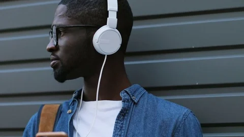 Side view of portrait of stylish young african american tourist listening to Stock Footage 77285968