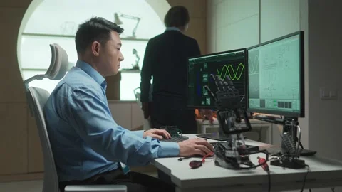 Side-view portrait of young qualified robotics engineer testing developing Stock Footage 228887329