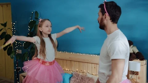 Side view of pretty daughter and her father doing ballet moves dancing together Stock Footage 112290424