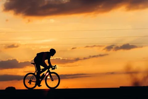 Side view of professional cyclist training on paved road Stock Photos