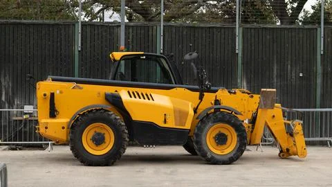Side view profile of yellow telehandler telescopic handler parked on construc Photos
