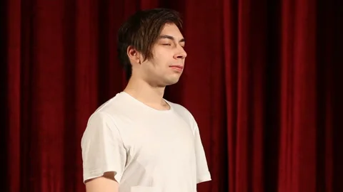 Side view profile young man standing by the red curtains Stock Footage 112216561