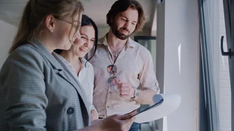 Side View of Realtor Explaining Contract to Homebuyers in Empty Flat Stock-Footage 311822901