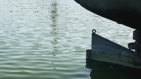 Side view of the rear of a large moored ship with a balanced rudder, close-u Видео 259506436