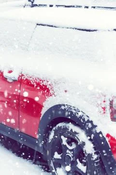 Side view of a red car covered after snowfall. Toned Stock Photos