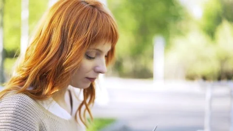 Side view of a red haired woman drinking tea outside 스톡 동영상 77283181