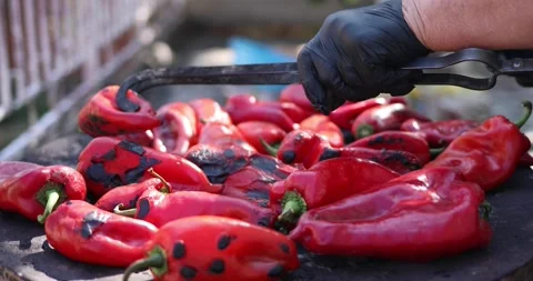 Side view of red peppers preparing for ajvar. Elderly hand flipping the peppers Stock Footage 207724118