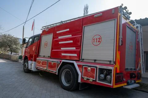 Side view of red traditional fire engine in front of local fire department Stock Photos