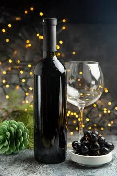 Side view of red wine bottle for celebration an empty glass and a black gra.. Stock Photos