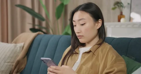 Side view relaxed young asian woman using smart phone surfing social media Vídeos de archivo 194168944