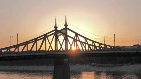 Side view of the road bridge across the river against the sun at sunset Stock Footage 201253908