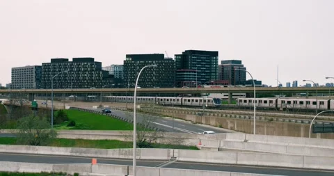 Side view of road junction and train traveling on rails. Wide shot of busy city Stock Footage 252889741