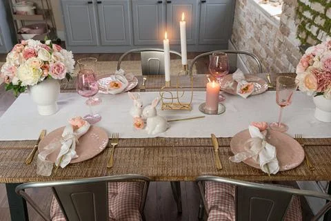 Side view of romantic cute table decor with glasses and lit candles. Plates w Stock Photos
