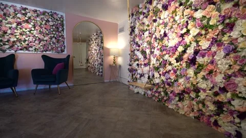 Side view of a rope swing beside a rose wall and velvet armchairs Stock Footage 345559008