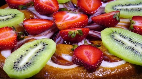 Side-view of round pie close up with sliced fresh strawberries and kiwi-fruit Stock Footage 78354024