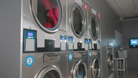 Side View Row of Industrial Laundry Machines Spinning Clothes in Laundromat Видео 318847923